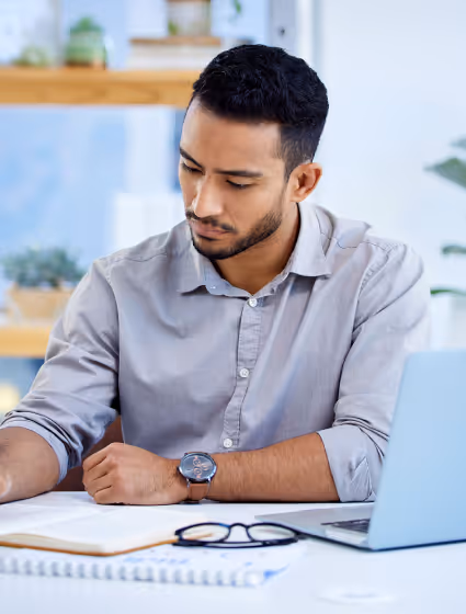 A partner reviewing his notes at a desk with a laptop